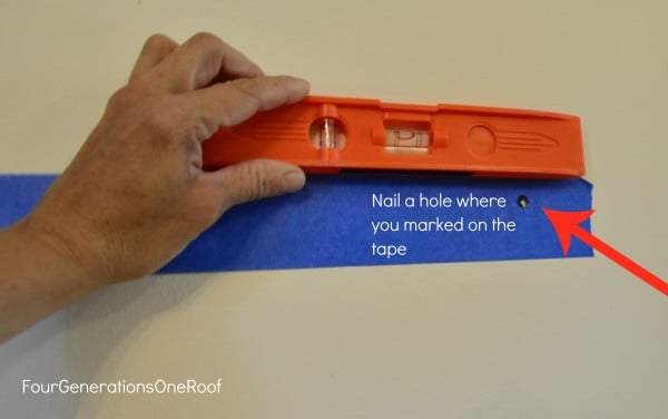 tape along wall with a level to mark nail holes to hang floating shelf