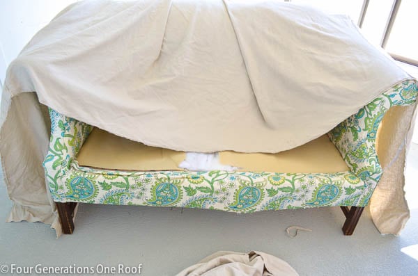 pottery barn white slipcover used to reupholster a couch , cement floor, pool house 