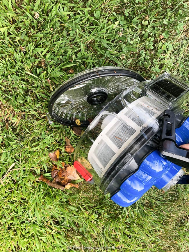 Hayward AquaVac 6 Series robotic pool cleaner filter being dumped on grass