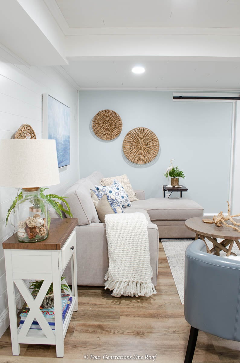 white plank wall, grey couch, blue medallion pillow, seagrass wall accent, coastal wall art, blue walls