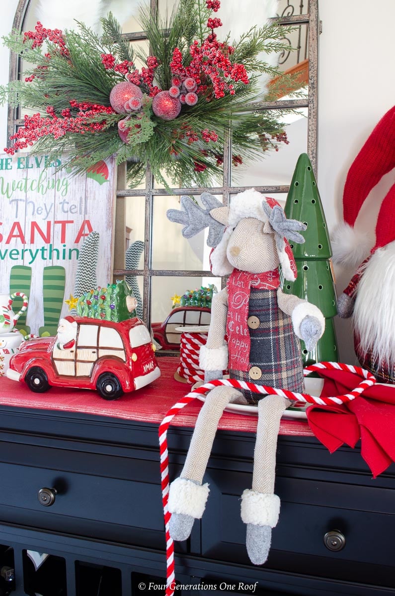 White fluffy faux fur holiday wreath layered on arched mirror with Christmas hot chocolate station below