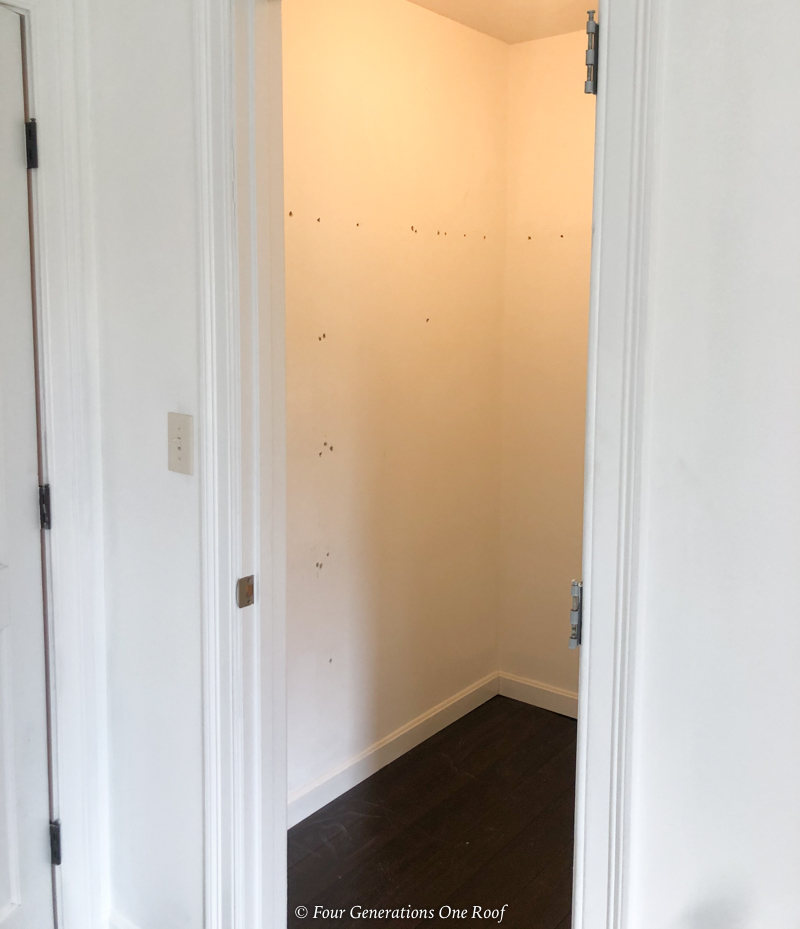 empty walk in closet with holes in wall from wire shelving