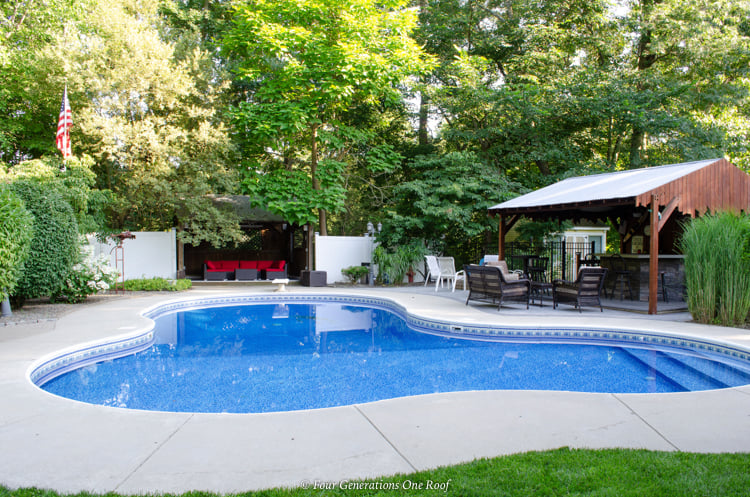 inground pool with patio and pool cabana with metal roof