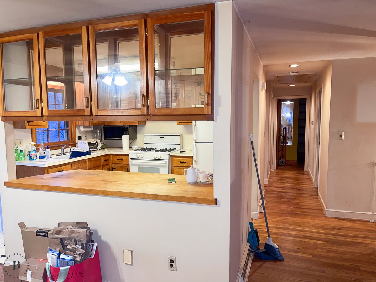 removing a kitchen wall and installing a load-bearing beam between a kitchen and living room to create an open-concept space