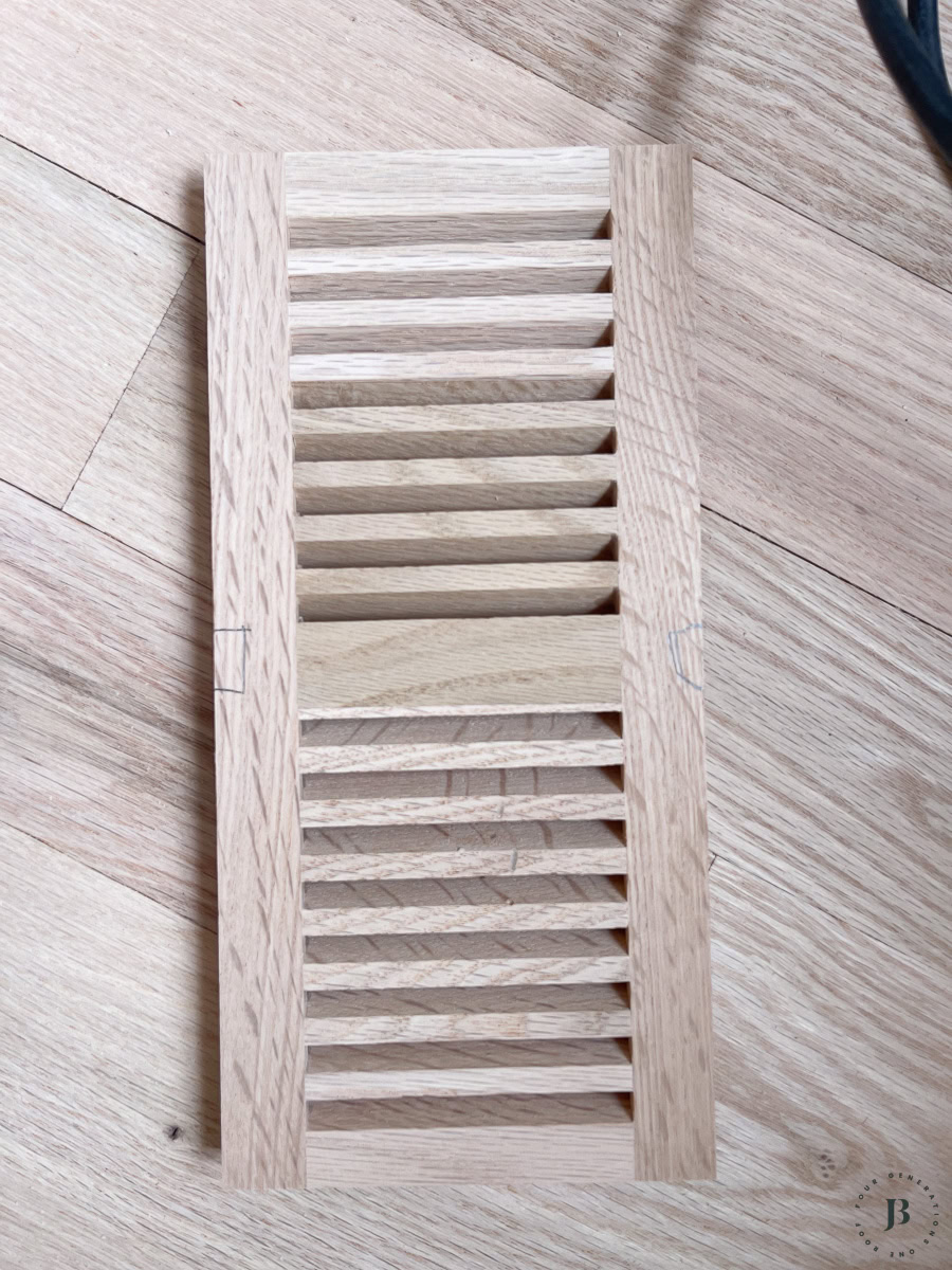 center grate piece of wood floor vent cover with square hole detail