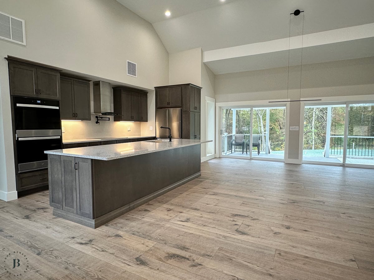 Two houses connected shared kitchen with dark brown cabinets and quartz countertops in multigenerational home