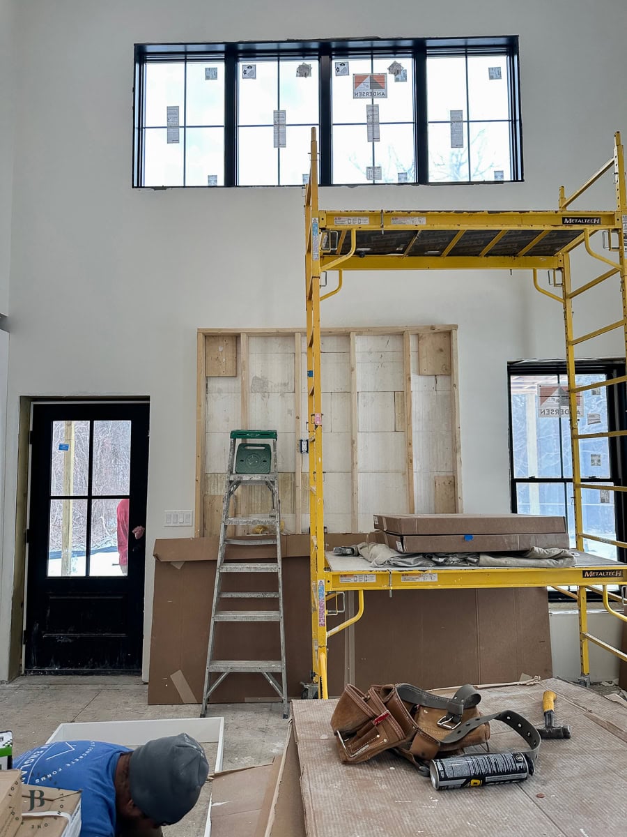 There it is. 😉 The main living space with the vault and the transom windows at the peak. The scaffolding is still up because finishing that upper portion requires it. But you can already see exactly what this room is going to feel like &mdash; light, open, not at all like 900 square feet.