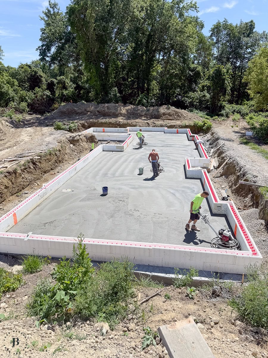 crew troweling and smoothing the freshly poured concrete slab inside the ICF walls