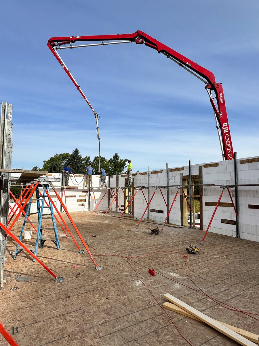 crew on scaffolding placing concrete into the ICF wall forms during the pour
