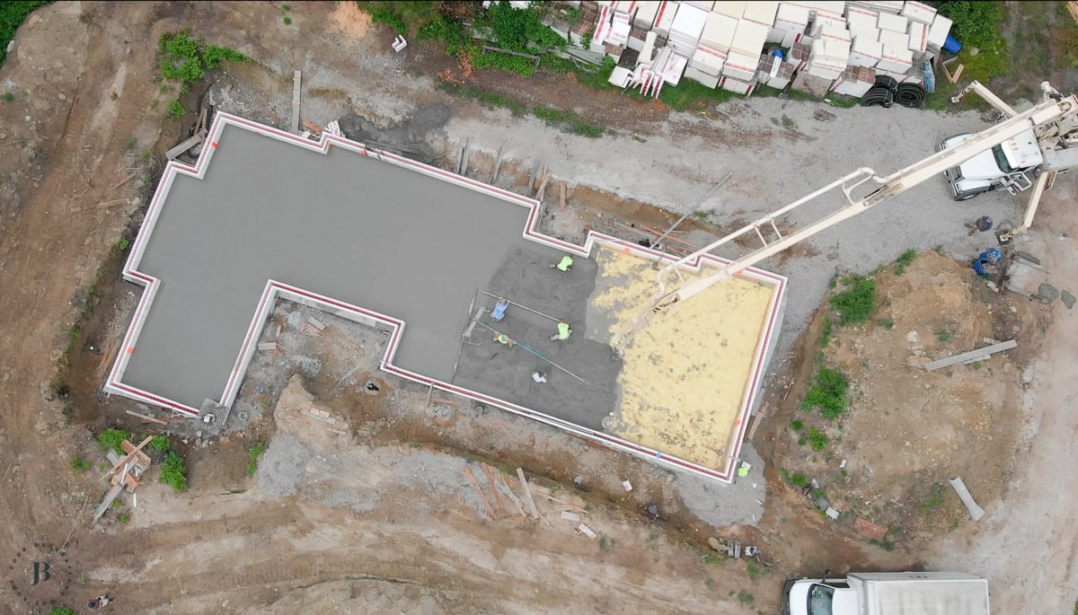 aerial view of yellow spray foam insulation applied to the foundation slab before the concrete pour