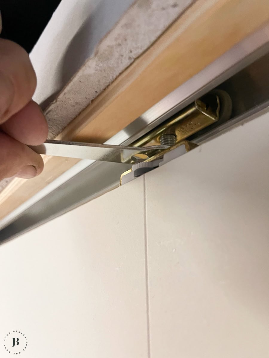tightening pocket door hardware on the top of the door slab